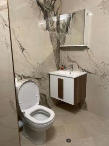 a bathroom with a white toilet and a sink at Catina`s Home in Burgas