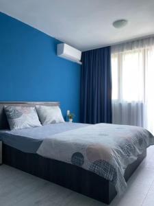 a blue bedroom with a bed with a blue wall at Catina`s Home in Burgas