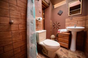 a bathroom with a toilet and a sink at Rumi Lodge Pisac in Pisac