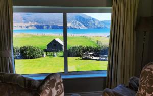 una ventana con vistas a un campo y un granero en Stella Maris Luxury Bed and Breakfast, en Keel