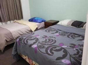 duas camas num quarto com duas camas sidx sidx em Mount Budget Accommodation em Tauranga