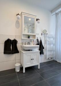 a bathroom with a white sink and a mirror at Modernes Studio Appartement mit Leseecke in Gernsbach