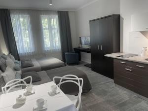 a living room with a couch and a table with chairs at Villa Aronia pokoje z aneksem kuchennym in Ustka