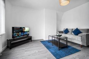 uma sala de estar com um sofá e uma televisão em 3 bed house/Free parking/contractors/Families em Bushbury