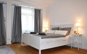 a white bedroom with a large white bed and a window at Modernes Studio Appartement mit Leseecke in Gernsbach
