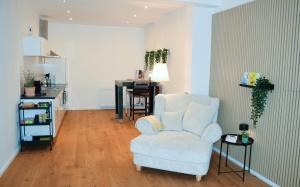 a living room with a white chair and a table at Modernes Studio Appartement mit Leseecke in Gernsbach