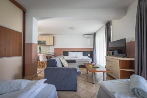 Una habitación de hotel con una cama y una sala de estar. en Fuk-tak's bungalow, en Star Dojran