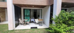 un porche cubierto con mesa y sillas en ILOA Residence Flat Alagoas en Barra de São Miguel
