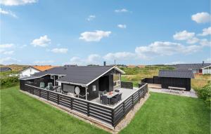 Havrvigにある3 Bedroom Cozy Home In Hvide Sandeの緑の芝生の上に黒屋根の家