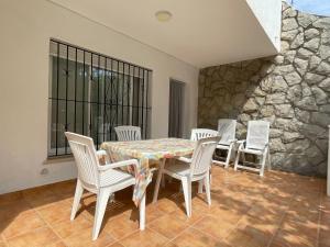 a dining room with a table and chairs and a stone wall at VACACIONES CHALET PEÑISCOLA 8-B Alquiler in Peñíscola
