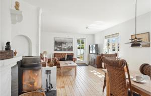 a living room with a fireplace and a table and chairs at Cozy Home In Skagen With Kitchen in Skagen