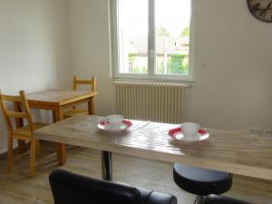- une table à manger avec 2 tasses et des chaises dans l'établissement Appartement Lisa, à Lézignan-Corbières