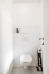 a bathroom with a white toilet in a room at House by StayStay I 24 Hours Check-In in Nürnberg