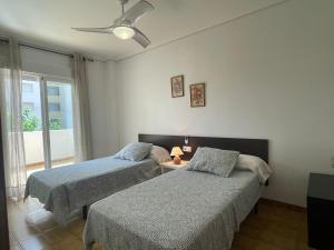 1 dormitorio con 2 camas y ventilador de techo en VACACIONES CHALET PEÑISCOLA 8-B Alquiler, en Peñíscola