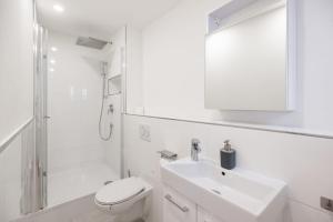 a white bathroom with a sink and a toilet at House by StayStay I 24 Hours Check-In in Nürnberg