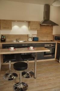 - une cuisine avec un comptoir en bois et des tabourets de bar dans l'établissement Appartement Lisa, à Lézignan-Corbières