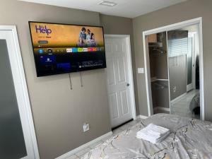 Modern 1 Bedroom Home W/ Sauna & Shower-Jets في كارسون: غرفة نوم مع تلفزيون بشاشة مسطحة على الحائط