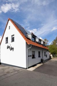 a white building with an orange roof at House by StayStay I 24 Hours Check-In in Nürnberg