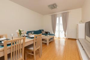 a kitchen and dining room with a table and a couch at Cozy Apartment Batalionów Chłopskich in Gdynia by Renters in Gdynia