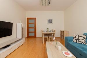 a living room with a blue couch and a table at Cozy Apartment Batalionów Chłopskich in Gdynia by Renters in Gdynia