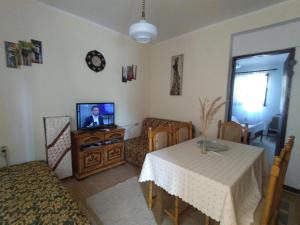 a living room with a table and a television at Igalo Apartman Despich in Igalo