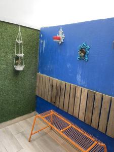 un banco en una habitación con una pared azul en Casa dos Poetas, en Caldas da Rainha