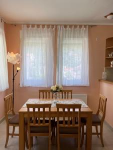 jadalnia ze stołem, krzesłami i oknami w obiekcie Hocevar apartment w mieście Herceg Novi