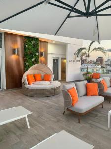 - un salon avec deux canapés et des oreillers orange dans l'établissement Central Suites Tower, à Saint-Domingue