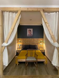 Un dormitorio con una cama amarilla y una mesa en Casa dos Poetas, en Caldas da Rainha