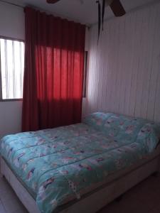 1 cama en un dormitorio con cortina roja en Amplio departamento en Godoy cruz en Godoy Cruz