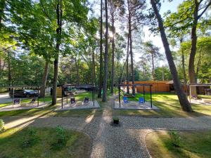 um parque com um baloiço e árvores em Villa Toskana em Pogorzelica