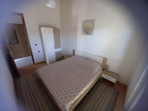 een kleine slaapkamer met een bed en een spiegel bij Apartman Privlaka in Privlaka
