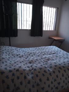 1 dormitorio con 1 cama con manta azul y blanca en Amplio departamento en Godoy cruz en Godoy Cruz