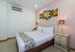 ein Schlafzimmer mit einem Bett und einem Wandgemälde in der Unterkunft Hotel Costa Bonita in Montería
