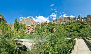 un puente sobre un río con una montaña en LIGNUM Casa Rural, en Ayna