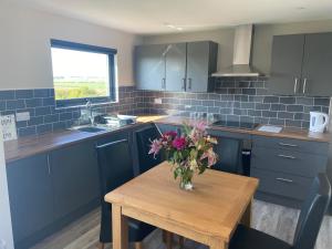 a kitchen with a table with a vase of flowers on it at Zara’s retreat in Doncaster