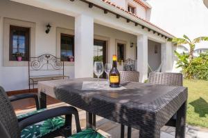 een tafel met een fles wijn en twee wijnglazen bij Casa do Moleiro in Caldas da Rainha