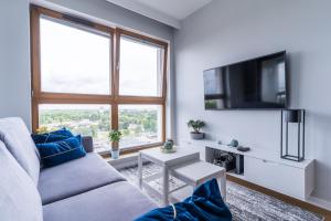 - un salon avec un canapé et une télévision dans l'établissement Hallera by Loft Apartments, à Gdańsk