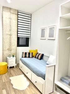 a bedroom with a bed with blue sheets and yellow pillows at Loft RioArga. Comodidad y Estiloa a 5 min Centro. Nuevo!!! in Pamplona