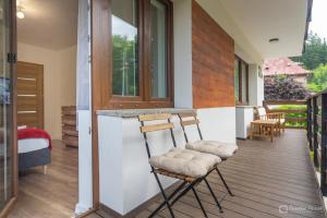 two chairs sitting on the porch of a house at Willa Rosa-apartamenty z prywatną sauną in Szklarska Poręba