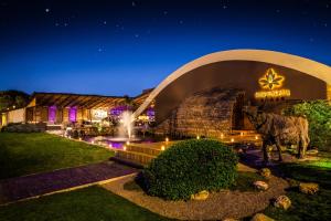 a building with a cow statue in front of it at night at Los Tajibos, Santa Cruz de la Sierra, a Tribute Portfolio Hotel in Santa Cruz de la Sierra