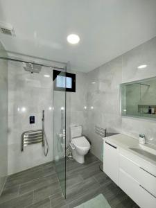 un bagno con wc e doccia in vetro di Ocean Front a Paul do Mar Altre 31 foto