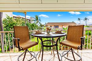 a patio table and two chairs on a balcony at Kihei Kai Nani 368 in Kihei