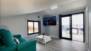 uma sala de estar com um sofá azul e uma mesa em Ocean Front em Paul do Mar