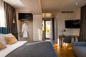 a bedroom with a bed and a chair and a television at L'Avventura Athens in Athens