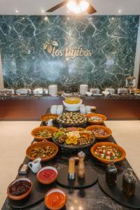 una mesa con muchos platos de comida. en Los Tajibos, Santa Cruz de la Sierra, a Tribute Portfolio Hotel, en Santa Cruz de la Sierra