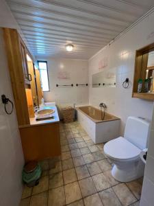 uma casa de banho com uma banheira, um WC e um lavatório. em House with a magical garden and sunroom em Höfn