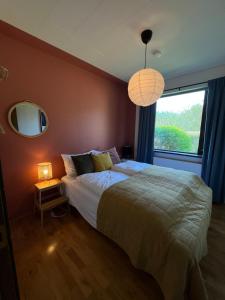 sypialnia z dużym łóżkiem i oknem w obiekcie House with a magical garden and sunroom w mieście Höfn