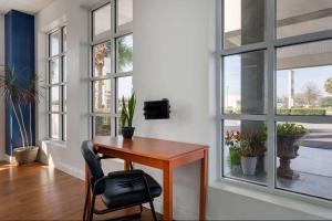 escritorio en una habitación con ventanas y silla en Baymont by Wyndham Marianna en Marianna