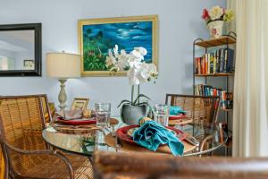 a dining room with a glass table and chairs at Hono Kai A4 in Wailuku